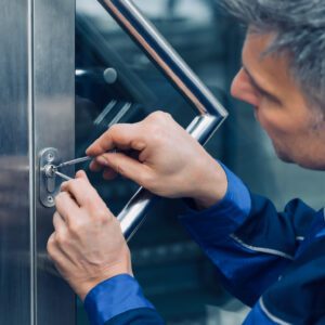 Homeowner cleaning a lock as part of routine lock maintenance tips