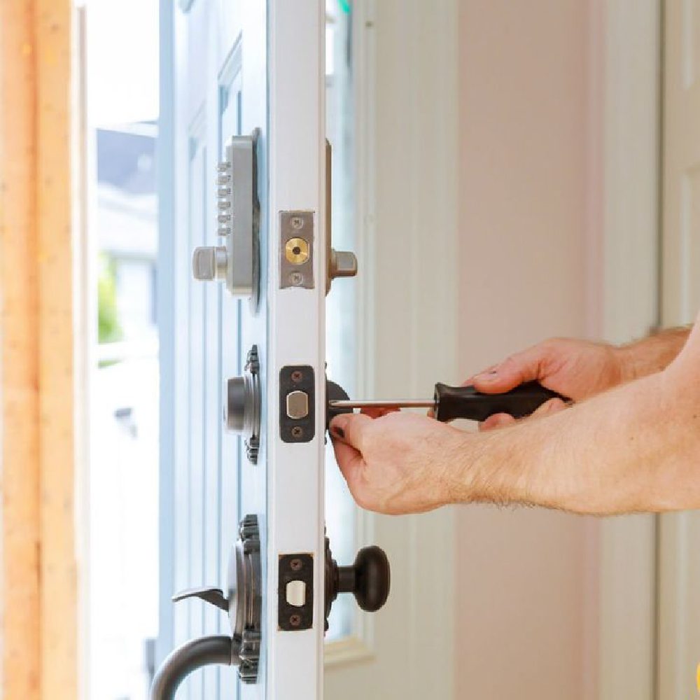 Homeowner performing lock maintenance tips on a front door lock